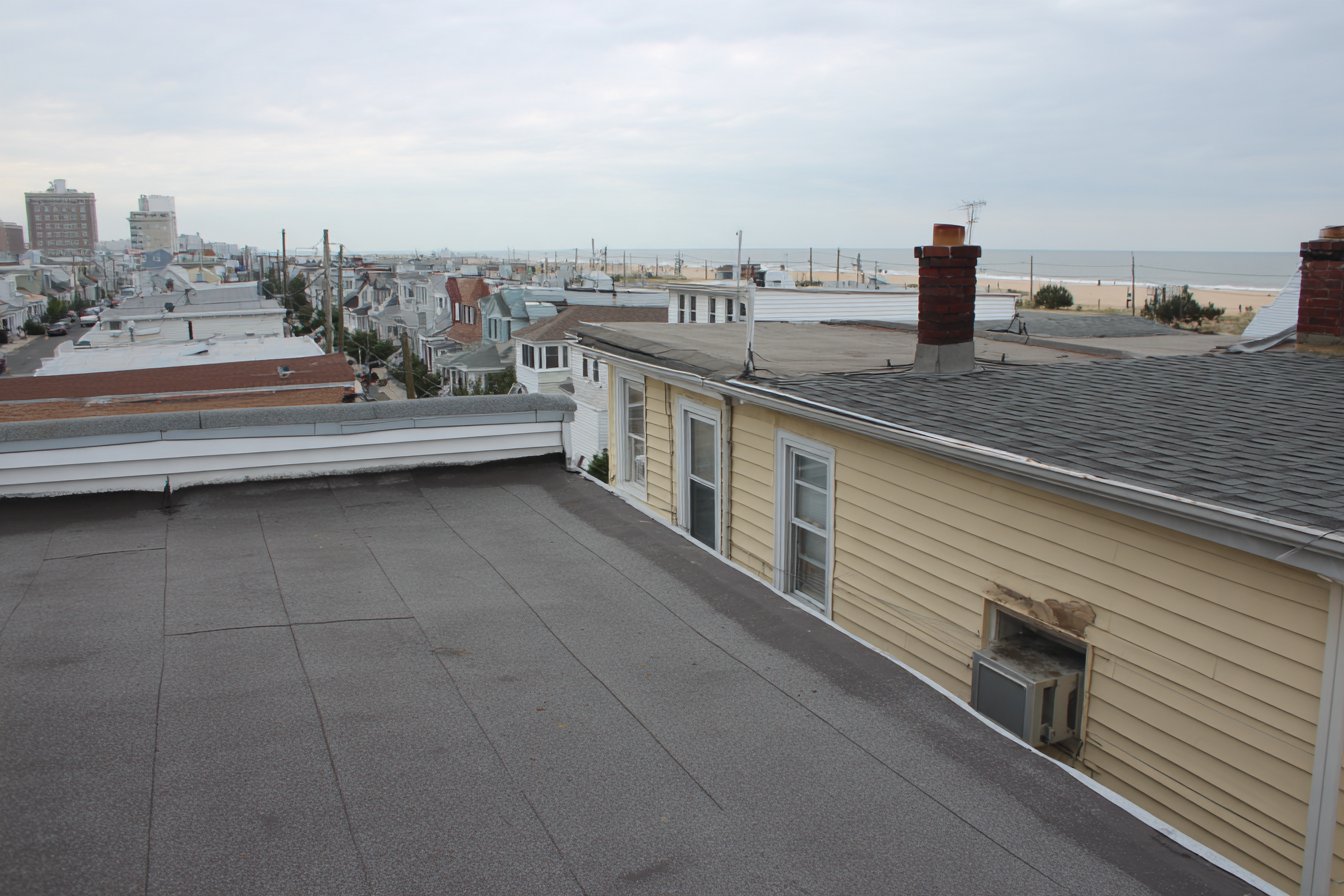 Flat modified bitumen roof on an attached row house in Arverne, Queens, with the Rockaway boardwalk and the Atlantic a few blocks behind