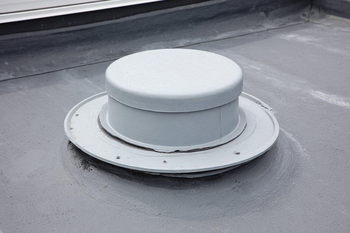 Close-up of new flashing sealed around a flat roof drain