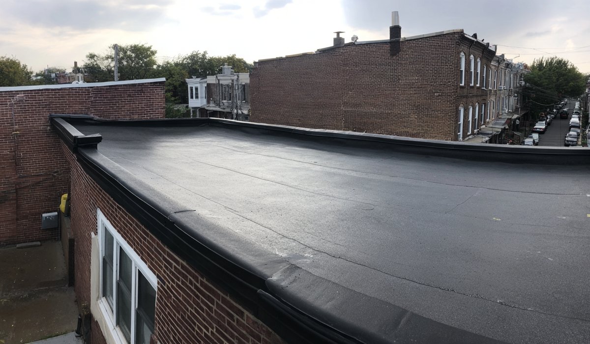 Resealed modified bitumen seams and new parapet flashing on a Sunnyside two-family home
