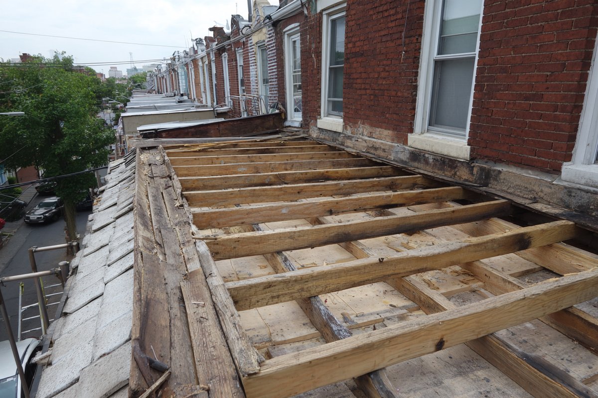 Exposed rafters and roof deck on a Queens house after the concrete tile came off, ready for the structural check